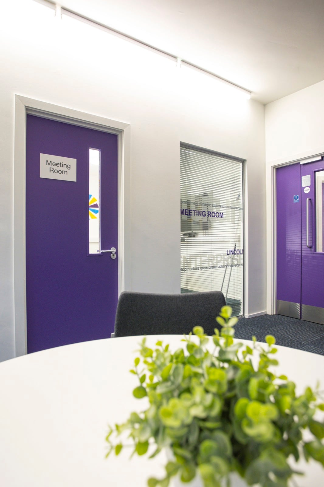 Meeting room doors off the breakout area, one glazed and etched with the word Enterprise