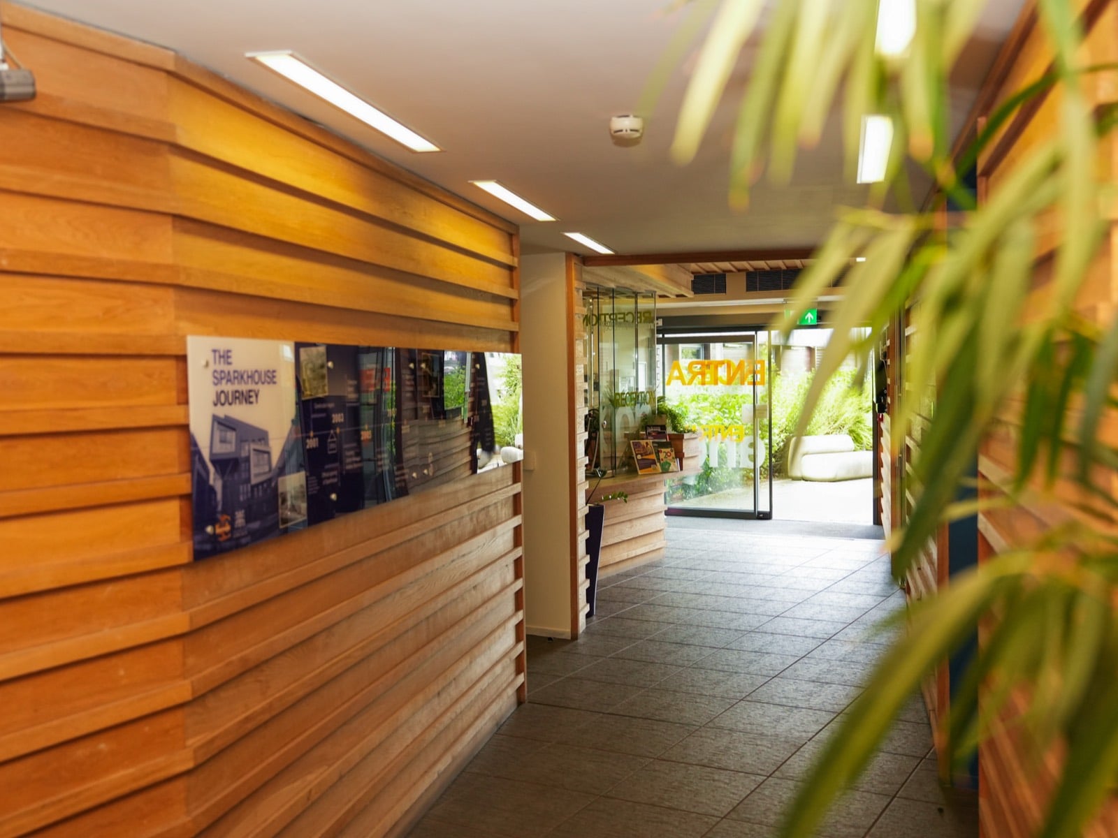 The timber-lined entrance corridor at Sparkhouse, leading past the Sparkhouse Journey display to reception