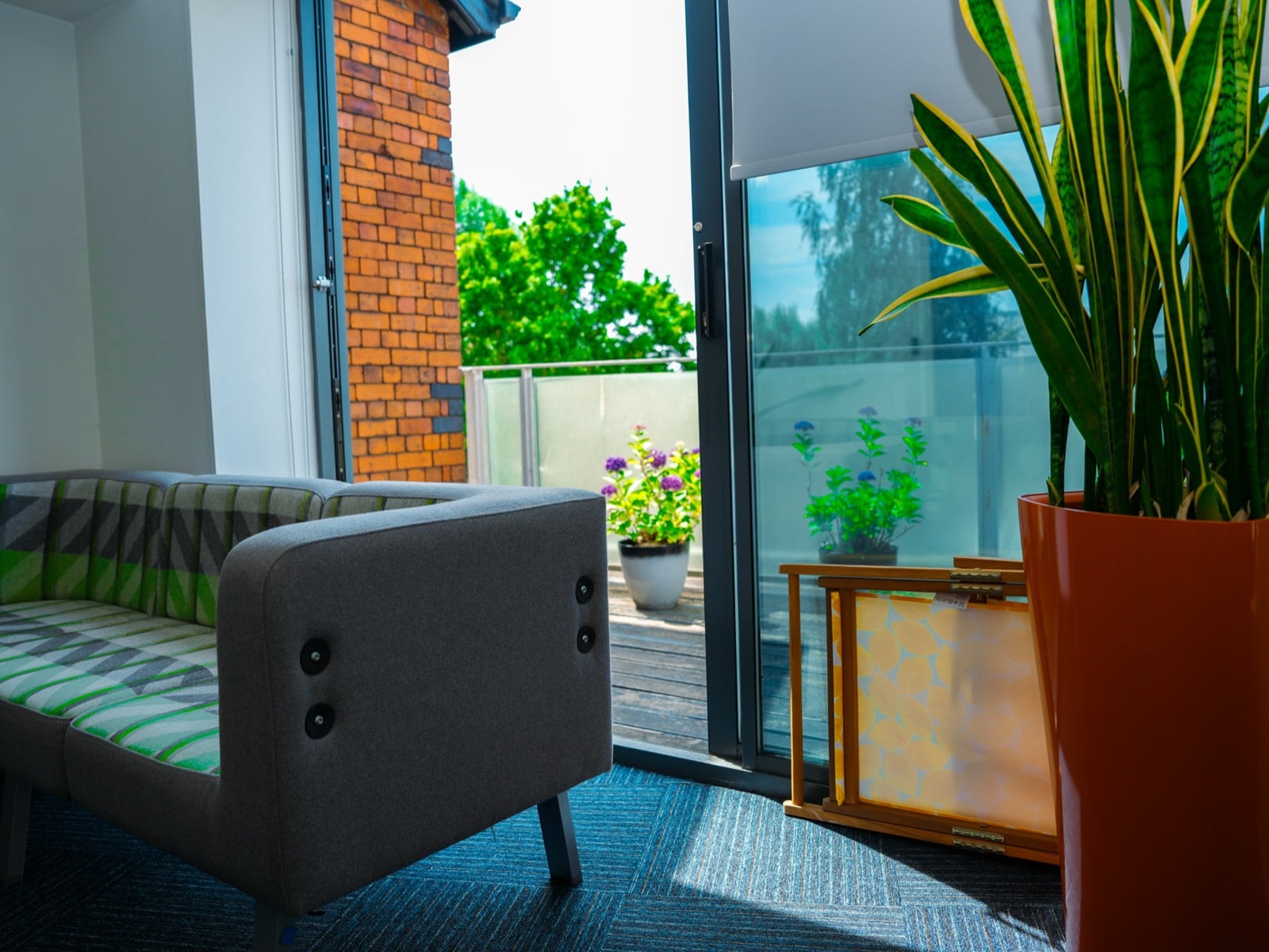 Soft seating and planting beside sliding doors onto a decked terrace
