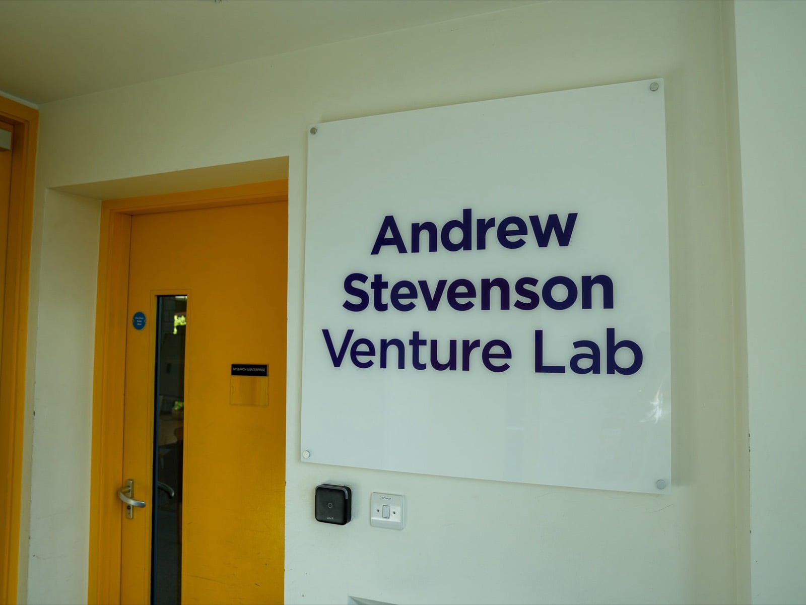 The Andrew Stevenson Venture Lab sign beside a yellow door