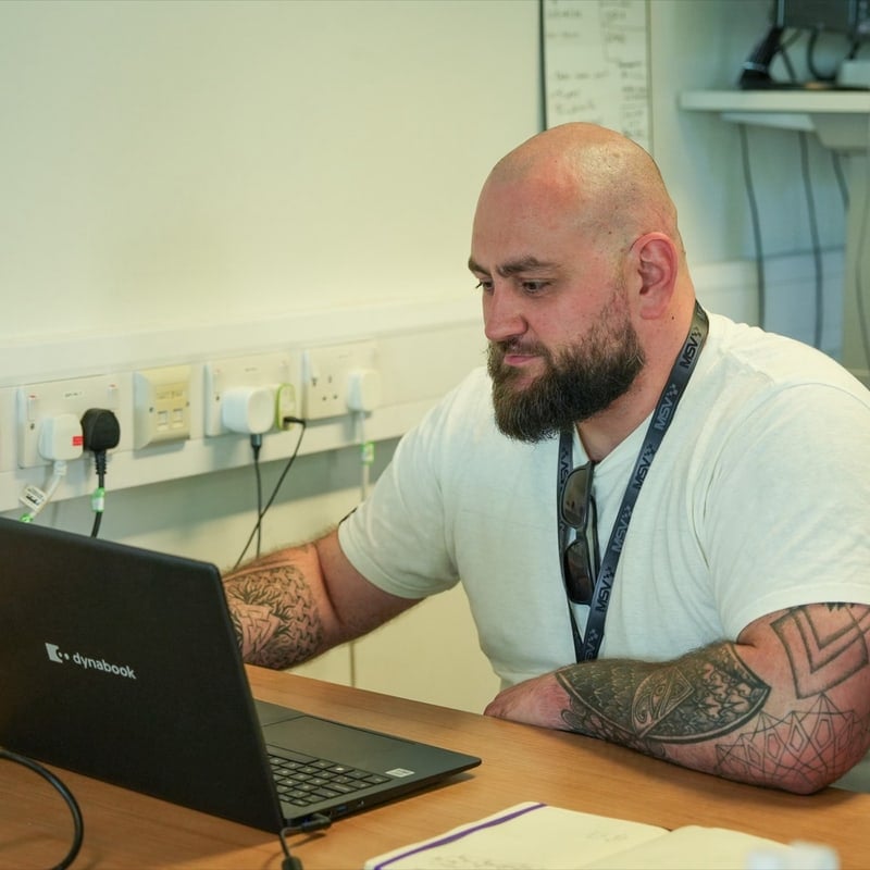 Spencer North of OptiU working at a laptop at his desk in Venture Lab