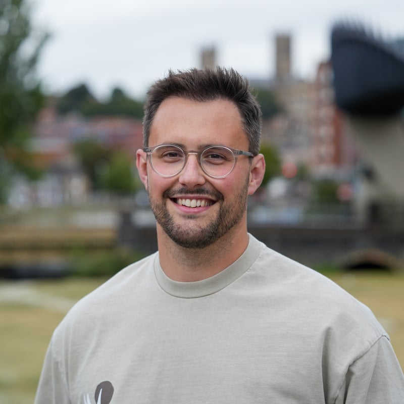 Tommy Atkins of Identity Agency, smiling to camera outdoors with Lincoln behind him