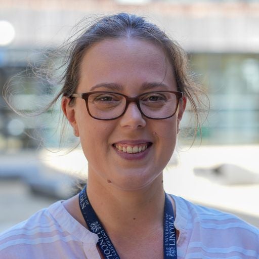 Christine Berrill, smiling to camera, wearing a University of Lincoln lanyard